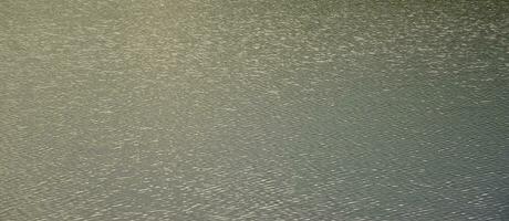 The texture of dark river water under the influence of wind, imprinted in perspective. Horizontal image photo