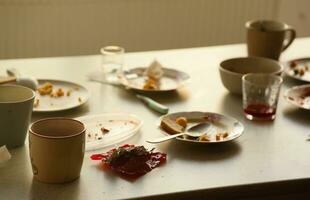 Empty dirty plates with spoons and forks on the table after meal. Banquet ending concept. Unwashed dishes photo