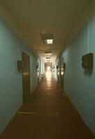 The gloomy corridor of a neglected public building. Public space in a poor residential high-rise building photo