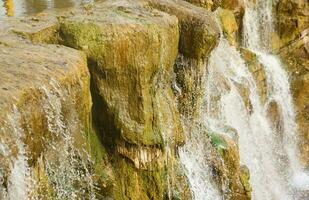 Beautiful waterfall between large rocks in autumn forest. Sofievskiy park in Uman, Ukraine photo