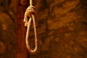 Noose in prison of old castle cellar and grunge stone wall photo