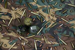 Different types of ammunition on a camouflage background. Preparing for war photo