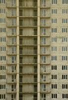 Textured pattern of a russian whitestone residential house building wall with many windows and balcony under construction photo