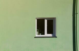 Vintage white window on mint green wall in sunlight photo