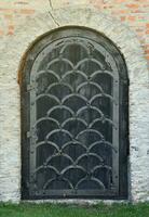 Very old solid door in brick stone wall of castle or fortress of 18th century photo