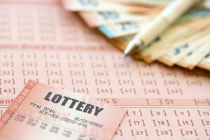 Lottery ticket and gambling receipt on table with pen and European Union euro money bills photo