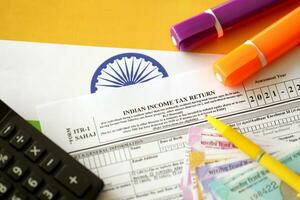 Indian income tax return blank form with pen and indian rupees bills photo