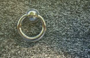 Metal ring on grave of cemetery. Rusty iron handle on granite tomb cover. An 19th century antique cemetery in Lviv photo