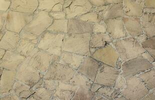 Background texture of an old castle stone wall with stones of various shapes photo