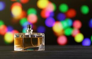 Women fragrance perfume bottle on dark festive background close up. Unnamed blank sprayer bottle of perfume photo