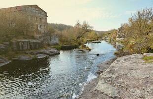 Rocky bank, mountain landscape. View of mountain river in early spring. Nature landscape, wilderness. Tikich river photo