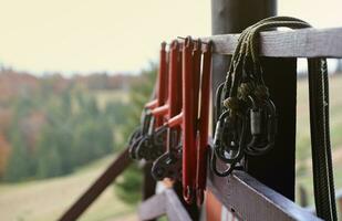 grande metal cierre mosquetones con soga, alpinismo engranaje colgando en el Tienda habitación. altura la seguridad aprovechar y arbolista equipo foto