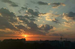 Beautiful sunrise with warm orange sunlight and beams through blue sky photo