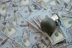 Grenade with a check against the background of huge amount of american dollar bills photo