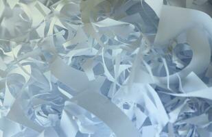 Shredded paper texture background, top view of many white paper strips. Pile of cut paper like box filler for shipping fragile items photo