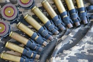 Ukrainian army fabric and machine gun belt shells lies on ukrainian pixeled military camouflage photo