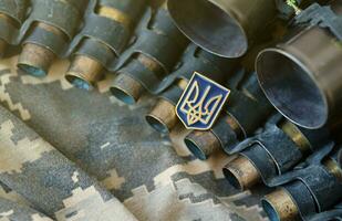 Ukrainian symbol on machine gun belt lies on ukrainian pixeled military camouflage photo