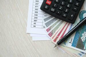 Iranian business calculations on table with iranian money and pen photo