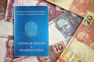 Brazilian work card and social security blue book and reais money bills photo