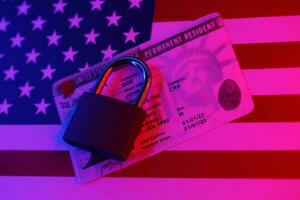 Permanent resident green card for US DV-lottery with small padlock on US flag photo