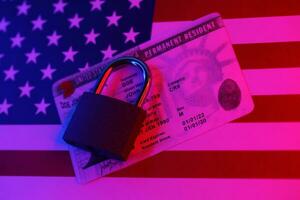 Permanent resident green card for US DV-lottery with small padlock on US flag photo