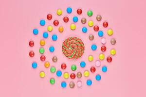 Sweet lollipop and candy on pink background photo