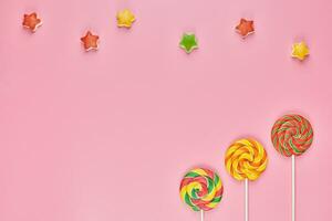 Sweet lollipop and candy on pink background photo