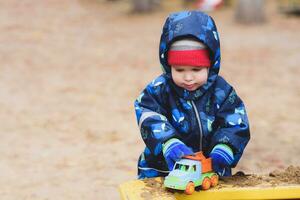 the kid plays cars on the street photo