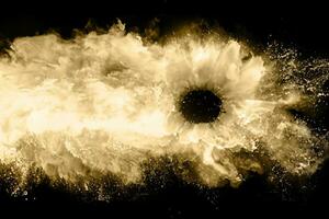 Golden powder explosion on black background. Freeze motion. photo