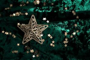 Abstract Christmas background with gold stars on a green velvet background. photo