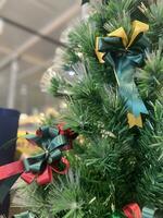 Christmas tree, green bow, and red glass ball hanging from a pine branch during the Christmas celebration. photo