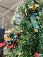 Christmas tree, green bow, and red glass ball hanging from a pine branch during the Christmas celebration. photo