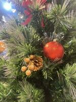 Navidad árbol, verde arco, y rojo vaso pelota colgando desde un pino rama durante el Navidad celebracion. foto