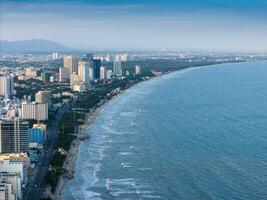 Panoramic coastal Vung Tau view from above, with waves, coastline, streets, coconut trees, Mount Nho in Vietnam behind the statue of Christ the King photo