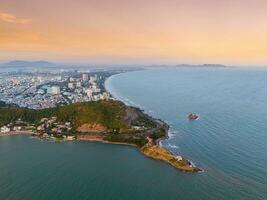 Panoramic coastal Vung Tau view from above, with waves, coastline, streets, coconut trees, Mount Nho in Vietnam behind the statue of Christ the King photo