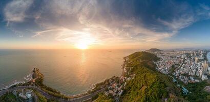 Panoramic coastal Vung Tau view from above, with waves, coastline, streets, coconut trees, Mount Nho in Vietnam behind the statue of Christ the King photo