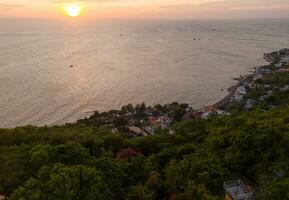 Panoramic coastal Vung Tau view from above, with waves, coastline, streets, coconut trees, Mount Nho in Vietnam behind the statue of Christ the King photo