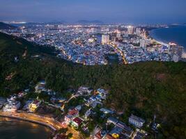 Panoramic coastal Vung Tau view from above, with waves, coastline, streets, coconut trees, Mount Nho in Vietnam behind the statue of Christ the King photo