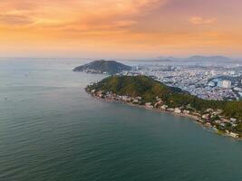 Panoramic coastal Vung Tau view from above, with waves, coastline, streets, coconut trees, Mount Nho in Vietnam behind the statue of Christ the King photo