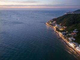 Panoramic coastal Vung Tau view from above, with waves, coastline, streets, coconut trees, Mount Nho in Vietnam behind the statue of Christ the King photo
