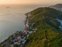 Panoramic coastal Vung Tau view from above, with waves, coastline, streets, coconut trees, Mount Nho in Vietnam behind the statue of Christ the King photo
