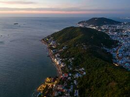Panoramic coastal Vung Tau view from above, with waves, coastline, streets, coconut trees, Mount Nho in Vietnam behind the statue of Christ the King photo