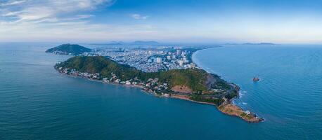 Panoramic coastal Vung Tau view from above, with waves, coastline, streets, coconut trees, Mount Nho in Vietnam behind the statue of Christ the King photo