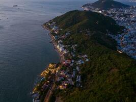 Panoramic coastal Vung Tau view from above, with waves, coastline, streets, coconut trees, Mount Nho in Vietnam behind the statue of Christ the King photo