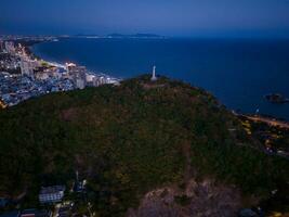 Panoramic coastal Vung Tau view from above, with waves, coastline, streets, coconut trees, Mount Nho in Vietnam behind the statue of Christ the King photo