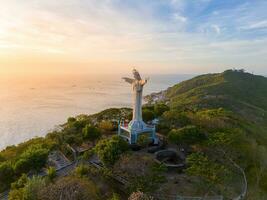 aéreo ver de vung tau ciudad, Vietnam, panorámico ver de el pacífico y hermosa costero ciudad detrás el estatua de Cristo el Rey en pie en montar no en vung tau ciudad. foto