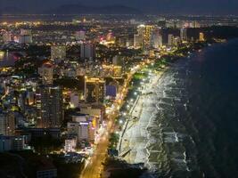 Panoramic coastal Vung Tau view from above, with waves, coastline, streets, coconut trees, Mount Nho in Vietnam behind the statue of Christ the King photo