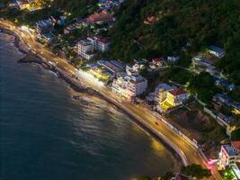 Panoramic coastal Vung Tau view from above, with waves, coastline, streets, coconut trees, Mount Nho in Vietnam behind the statue of Christ the King photo