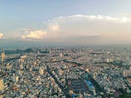 Panoramic view of Saigon, Vietnam from above at Ho Chi Minh City's central business district. Cityscape and many buildings, local houses, bridges, rivers photo