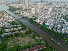 Panoramic view of Saigon, Vietnam from above at Ho Chi Minh City's central business district. Cityscape and many buildings, local houses, bridges, rivers photo